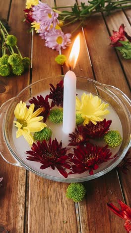 floating flowers and candle arrangement on wooden table