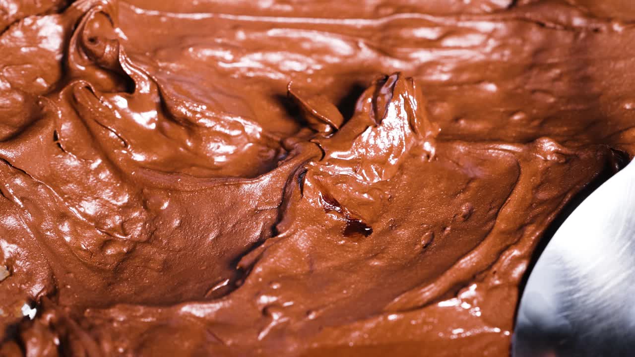 una cuchara para mezclar la masa de chocolate rica y cremosa