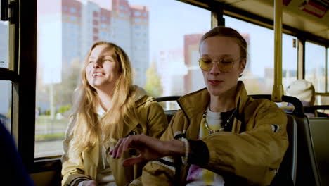 una pareja joven sentada en el autobús.