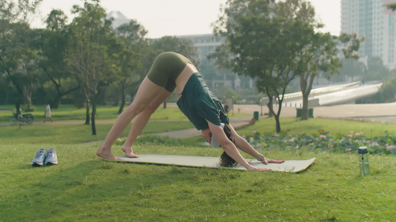 mujer practicando yoga al aire libre en el parque
