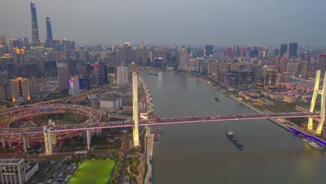 aerial drone motion time lapse of traffic on nanpu bridge spiral road day to night , shanghai, china in 4k video