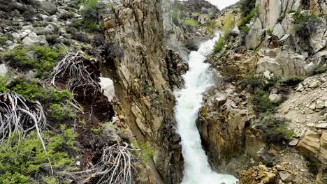Sierra-Nevada-snowpack-melts-into-rushing-Bishop-creek-waterfall-drone-shot