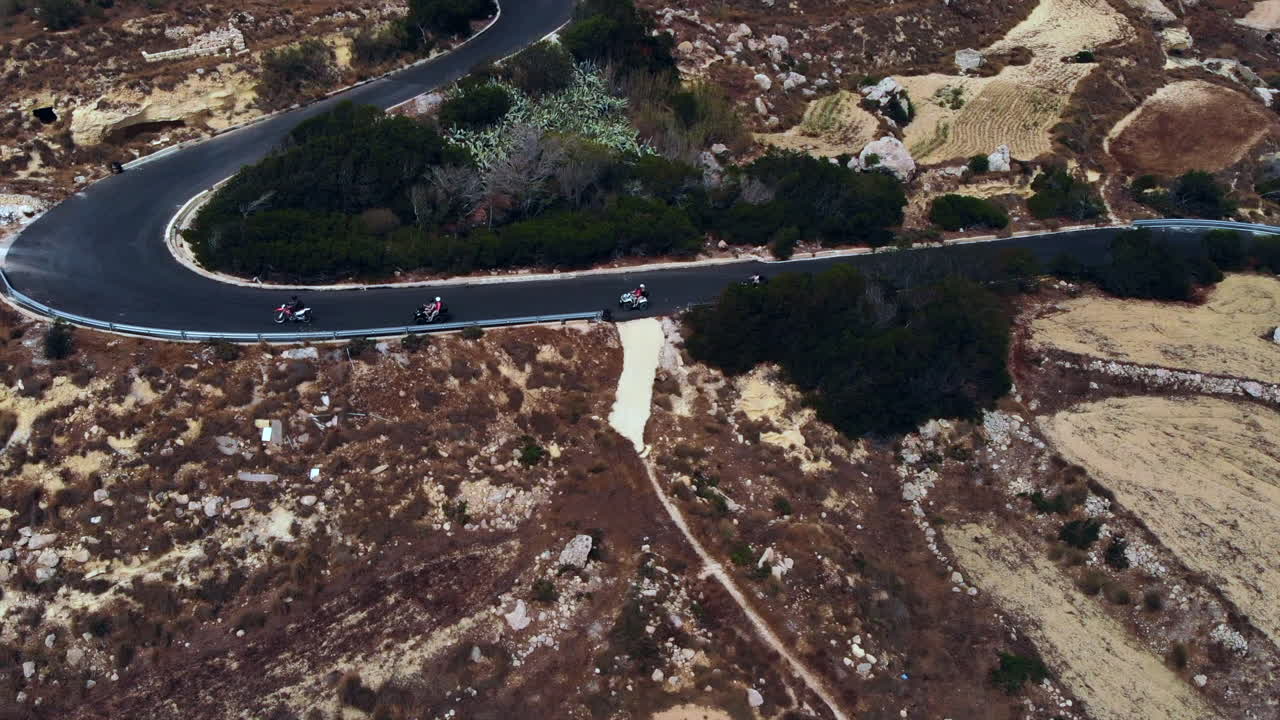 grupo de quads en bicicleta por la sinuosa carretera de la isla de gozo, malta