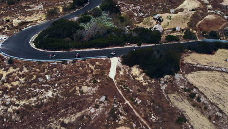 grupo de quads en bicicleta por la sinuosa carretera de la isla de gozo, malta