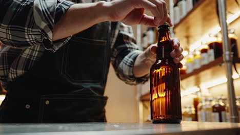 man capping beer bottles in brewery