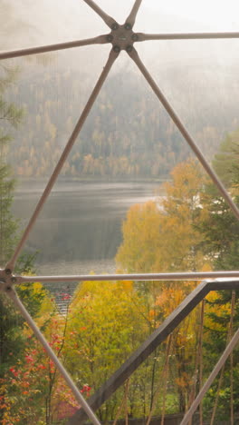lake view from glass balcony at glamping house. peaceful retreat to rest enjoying serene ambiance of autumn nature. glamping hotel bungalow for rent