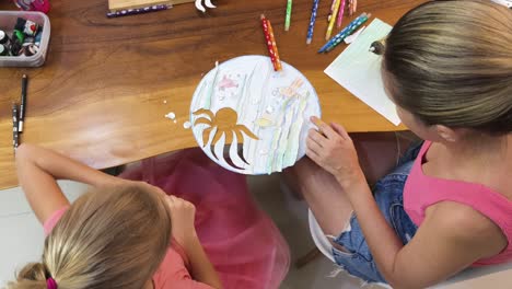 mother and daughter create an underwater scene art project