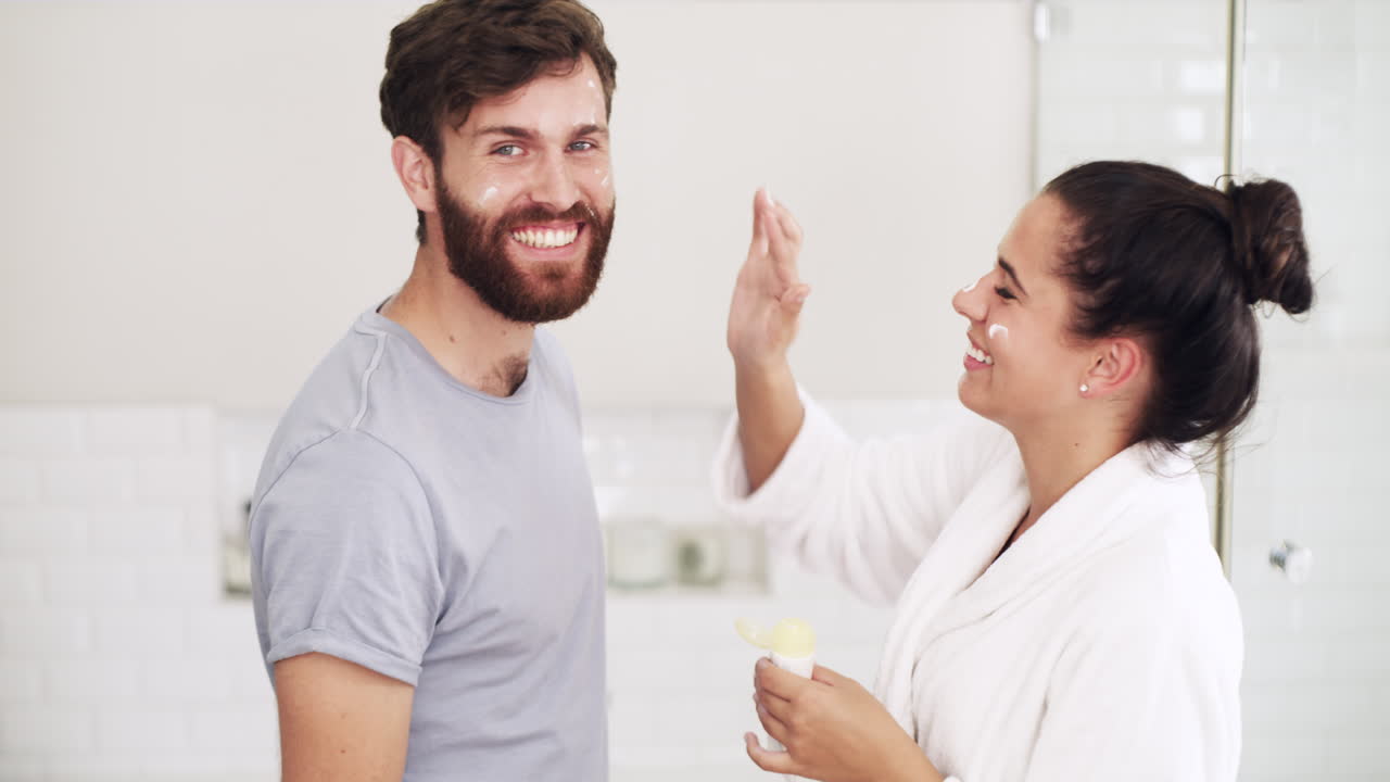 pareja feliz aplicando crema facial