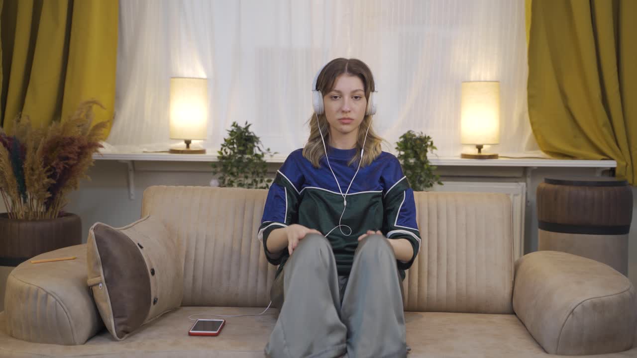 mujer joven escuchando música con auriculares es infeliz y triste.