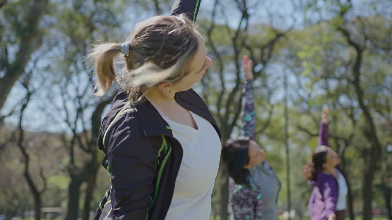 mujeres practicando yoga al aire libre en un parque