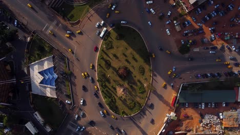 aerial top down, cars driving around roundabout in downtown yaounde, capital of cameroon