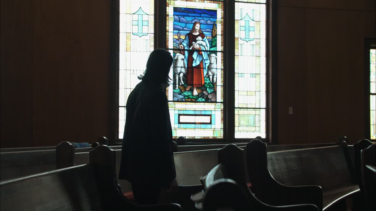 A Christian man, priest, preacher, pastor walking in spiritual reflection and worship while praying inside old church building, creating a cinematic and contemplative mood