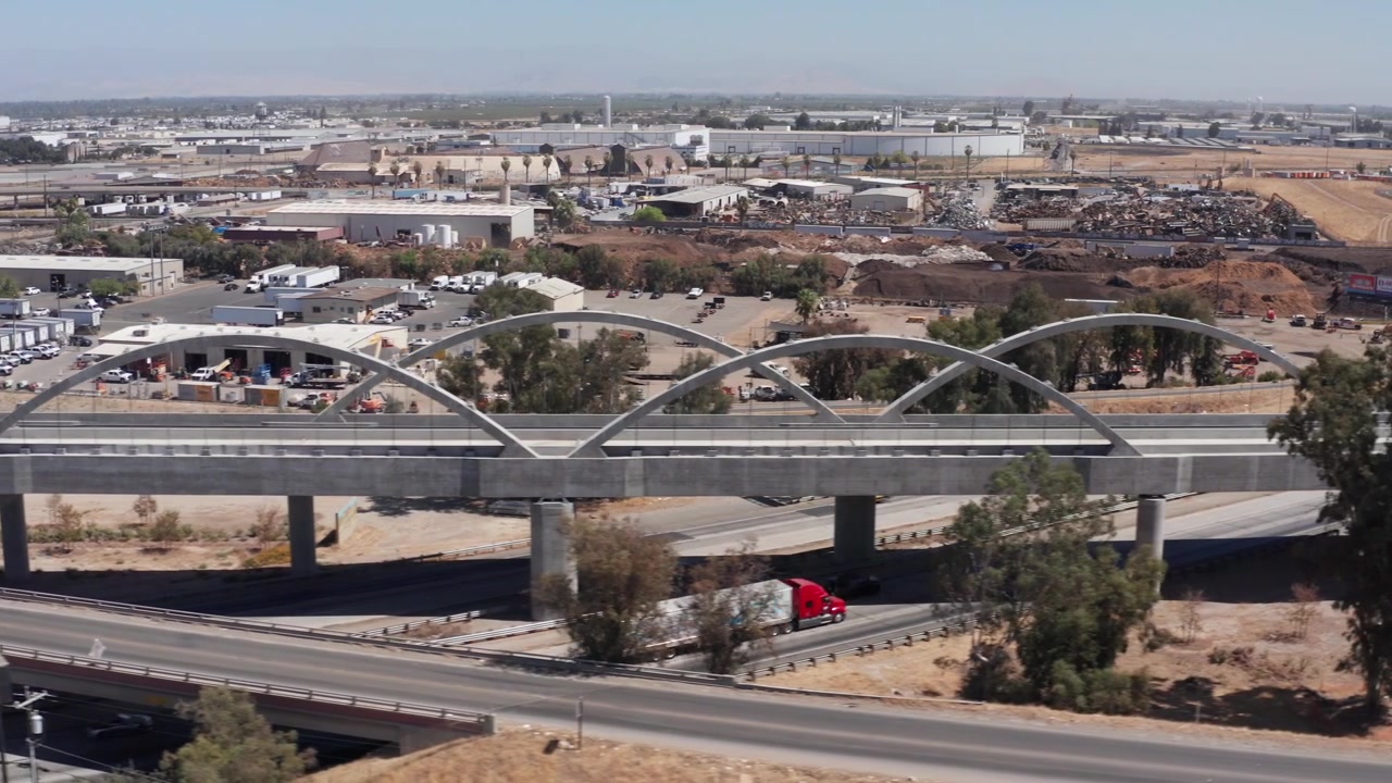 Ripresa aerea bassa con carrello lungo il binario della ferrovia ad alta velocità della California sopra il Viadotto Cedar a Fresno, California. 4K
