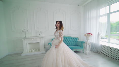 Bride in interior of large bright room. Beautiful bride enjoying her wedding day