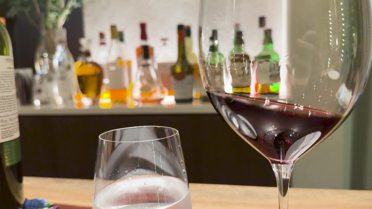 Primo piano di vino rosso che vortica all'interno di un bicchiere su un bancone da bar in Giappone.