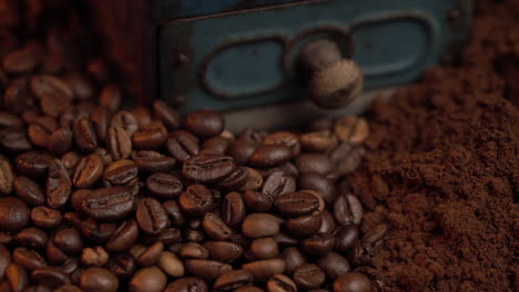 granos de café, molinillo vintage y café molido fino, de cerca
