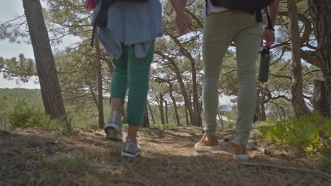 pareja de mochileros tomados de la mano y caminando al aire libre