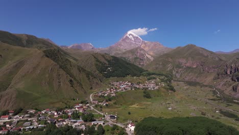 drone ascends above stepantsminda, georgia on beautiful summer day