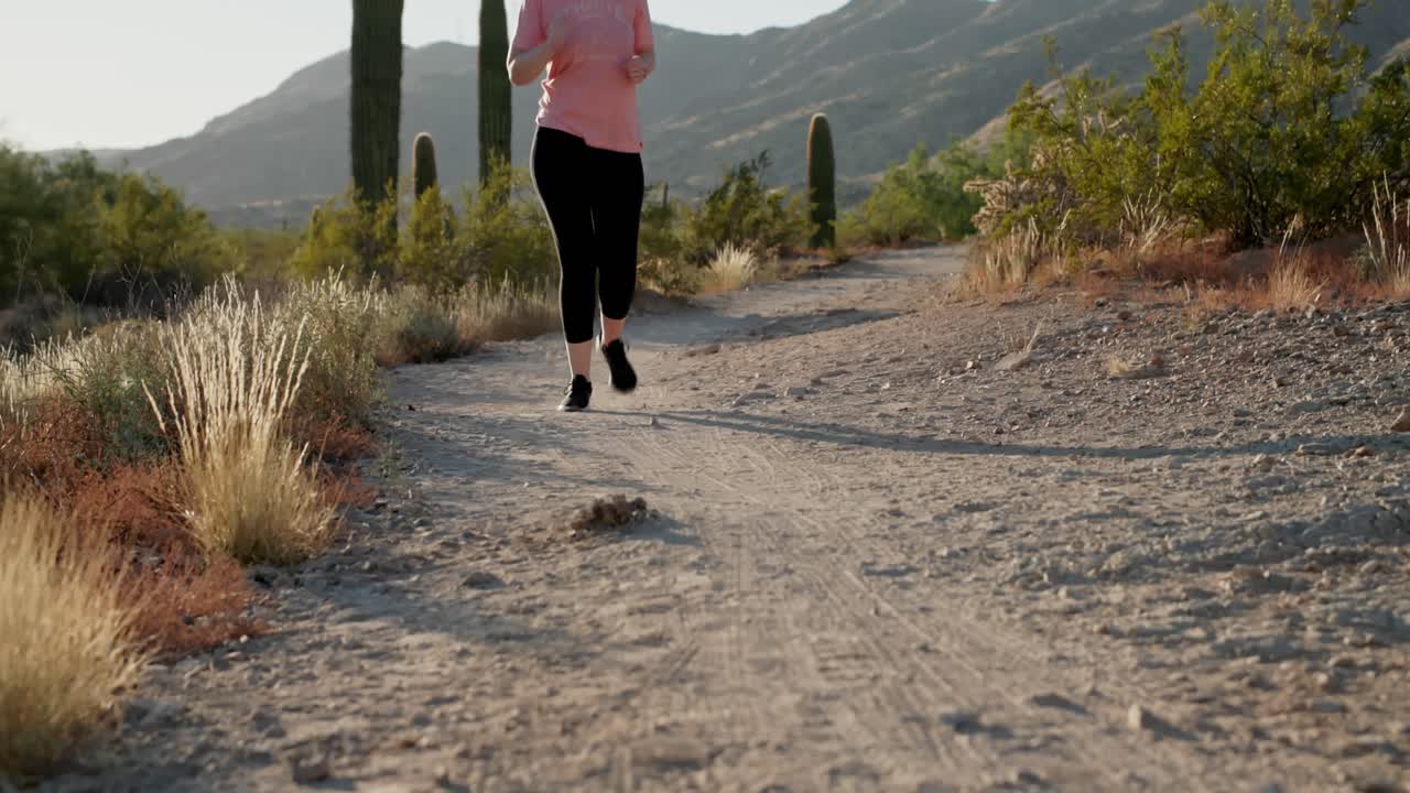 mujer joven deportiva corriendo en el desierto americano durante el atardecer