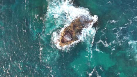 Top-down-descending-shot-of-small-rock-Island-off-coast-of-Stradbroke-Island