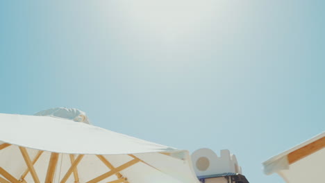 a row of white umbrellas against the blue sky in a luxury hotel