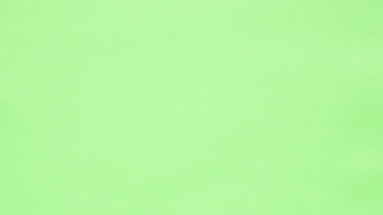 Green crumpled paper unfolds on orange in a stop motion transition
