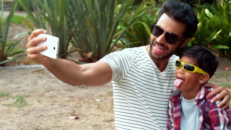 father and son taking selfie with mobile phone