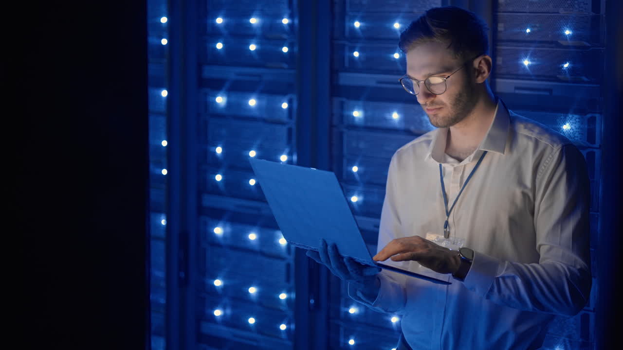 centro de datos se especializa en coworking en la sala de servidores segura del ciberespacio. administrador masculino apuntando al gabinete del servidor de errores ejecutando diagnósticos en computadora portátil