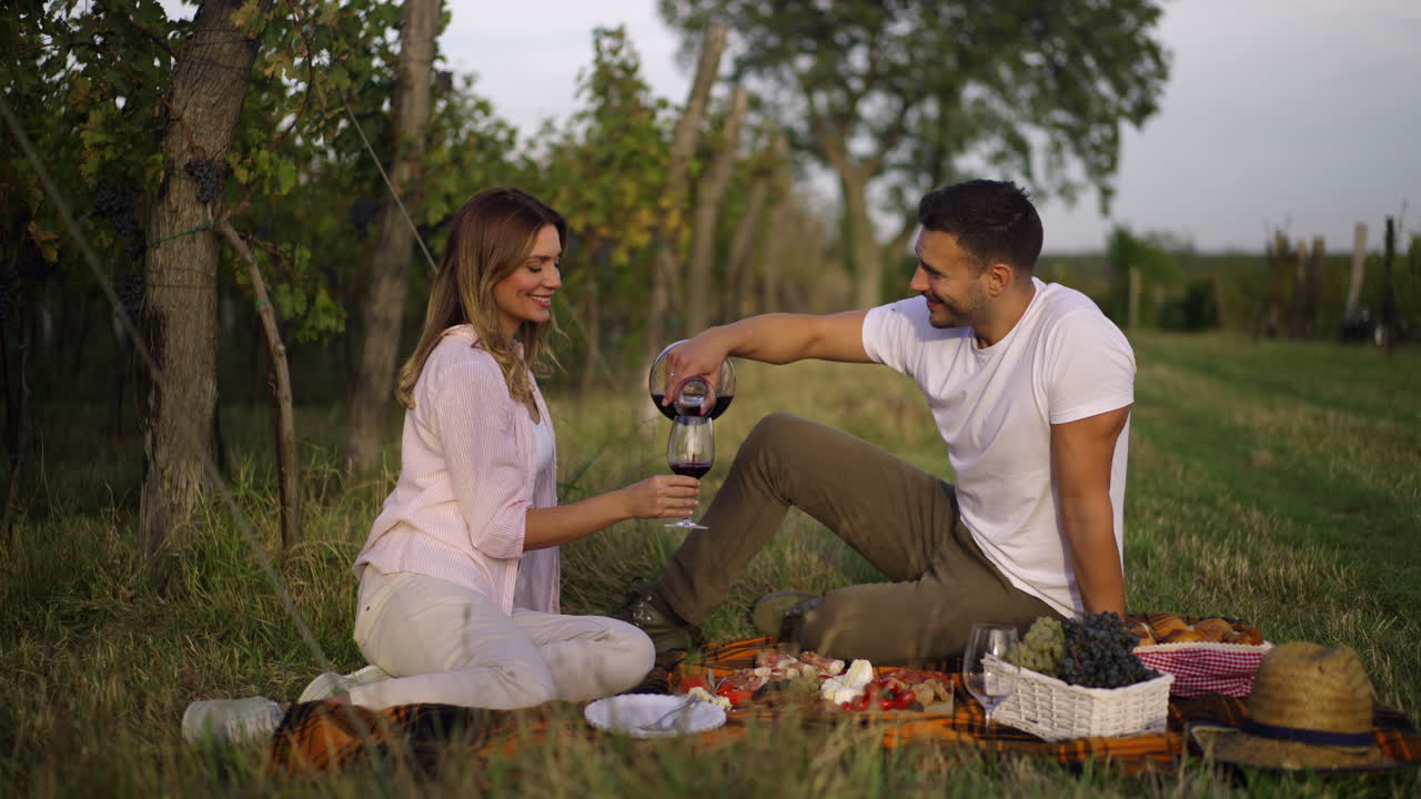 Couple enjoying a picnic with wine in a vineyard