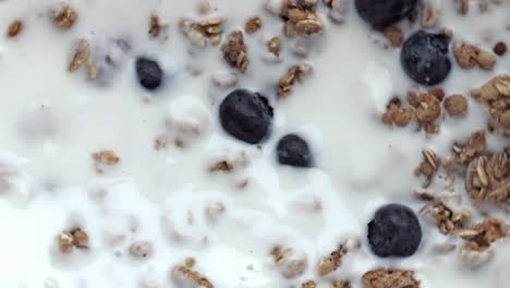 Müsli-Mit-Beerenfüllung-Aus-Der-Nahaufnahme.-Bio-Blaubeeren,-Schwimmender-Kalziumjoghurt