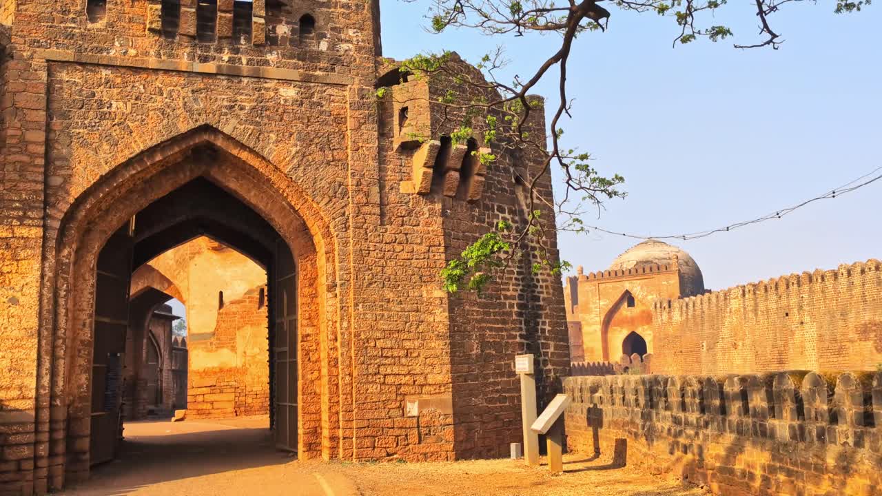 Sherja Darwaza Portindgang med Gumbad Darwaza og fæstningens sidevæg i Bidar, Karnataka, Indien. Dagtid, indskydende optagelse, håndholdt optagelse, 4K.