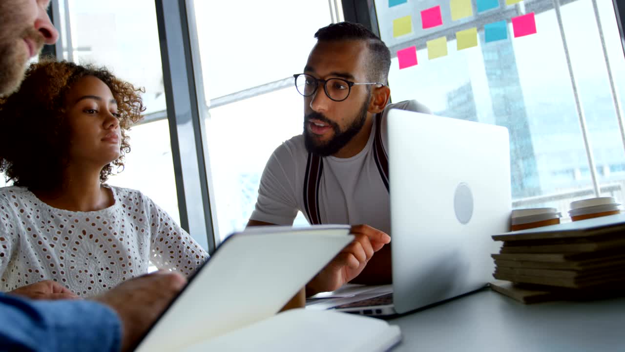 Business colleagues discussing over laptop 4k