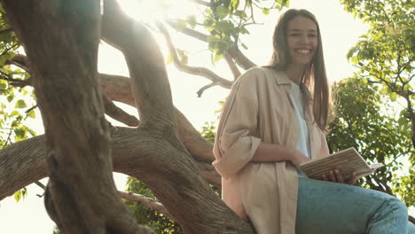 woman reading book sitting on tree