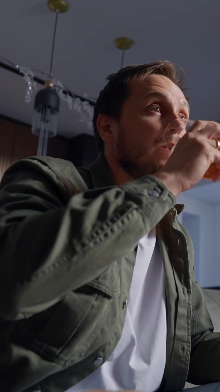 Excited Man Celebrates Victory While Watching and Drinking Beer