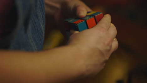 unidentifiable hand plays with rubik's cube and gives up, close up