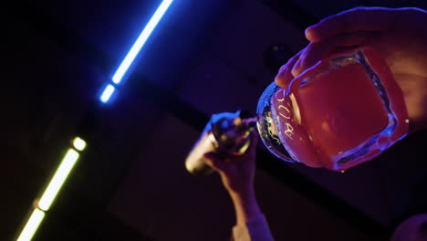 bartender pouring cocktail in glass