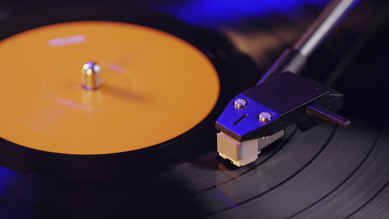 Retro Vinyl record player playing music, close-up macro shot of vintage LP disc old phonograph spinning. Retro music player.