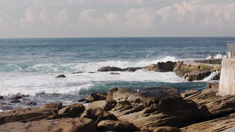 waves crash along the seawall near the bondi beach ocean lap pool in australia