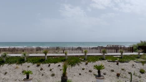 Low-aerial-dolly-above-a-private-villa-with-a-pool-overlooking-the-beach-at-Frontignan