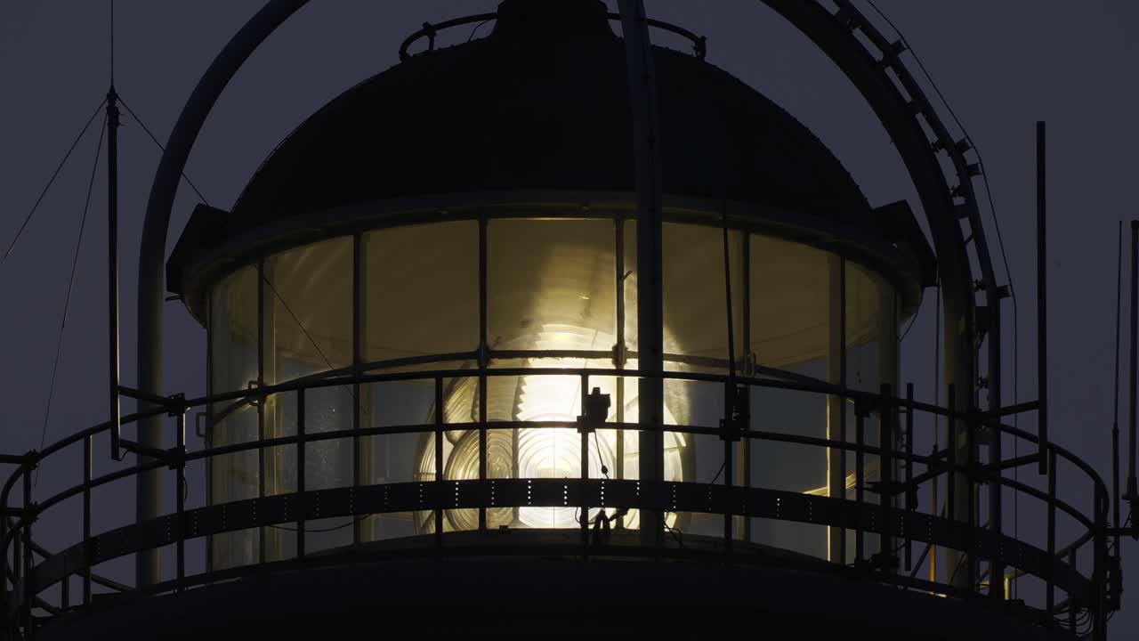 저녁에 등대에서 회전하는 비스듬한 프레넬 렌즈의 전망