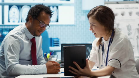 physician comforting her male patient by holding his hand and giving her support