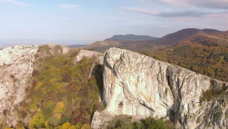 aerial panning shot of big high rocks on the edge of a mountain