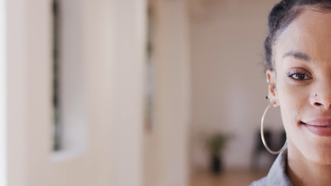 retrato de una feliz mujer biracial mirando a la cámara en un estudio de baile, cámara lenta