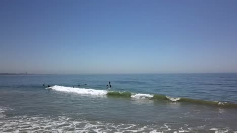 Surf-student-from-a-surf-school-gets-his-first-wave-Calmer-aerial-view-flight-pursuit-flight-drone-footage
in-California-at-Malibu-Topanga-Beach-USA-2018