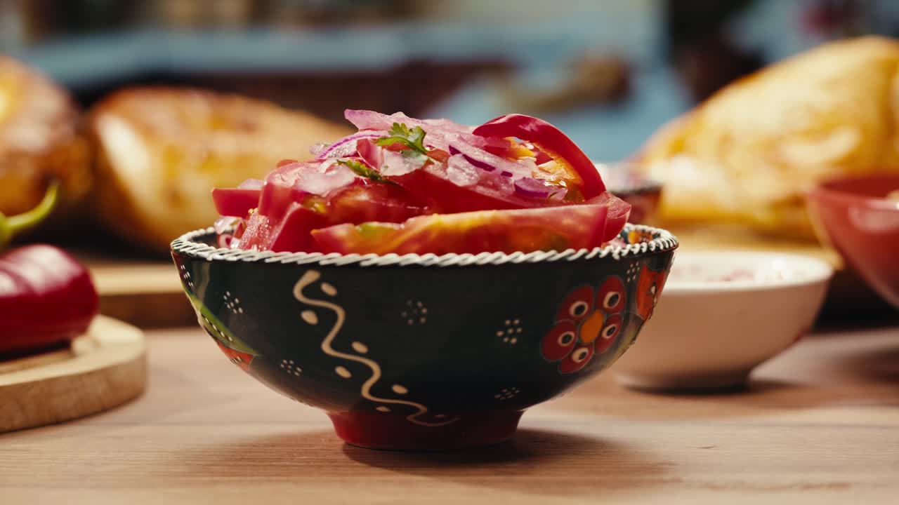 mano sosteniendo un plato de tomate y ensalada de cebolla roja