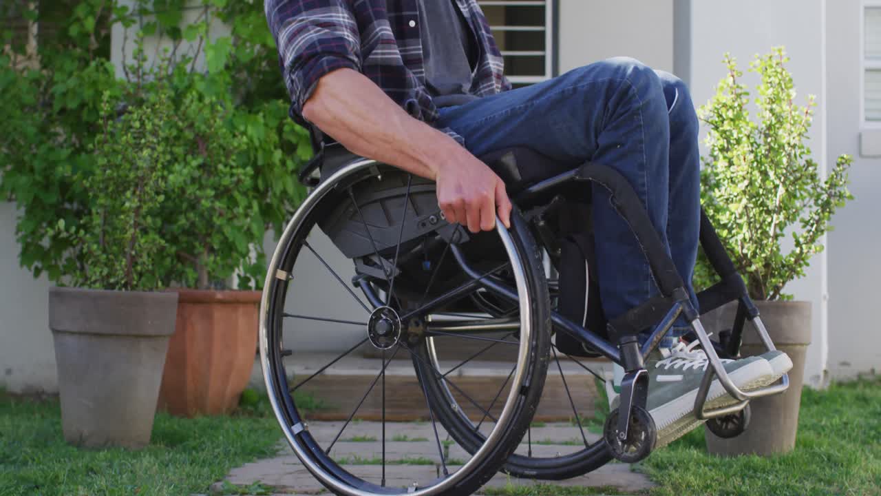 retrato de un hombre discapacitado caucásico sonriente en silla de ruedas mirando a la cámara