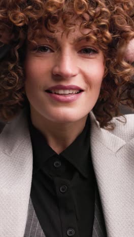 cheerful female executive in formal suit in studio. vertical orientation