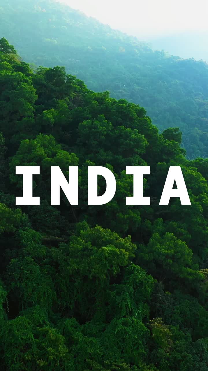 video disparo vertical de drones aéreos de bosques y montañas en la india con gráficos animados deletreando la india