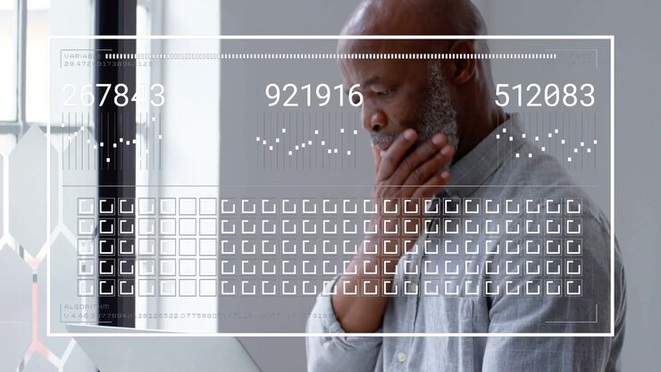 Businessman holding laptop by window typing and generating numeric charts, icons analyzing metrics