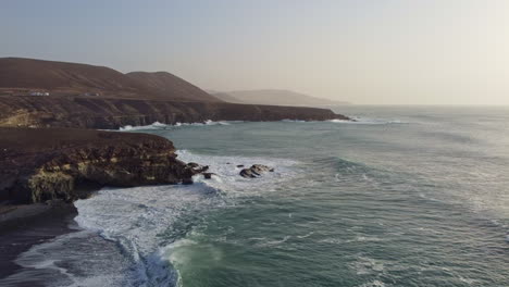 ajuy, fuerteventura, in a stunning sunset, as waves roll onto the cliffs